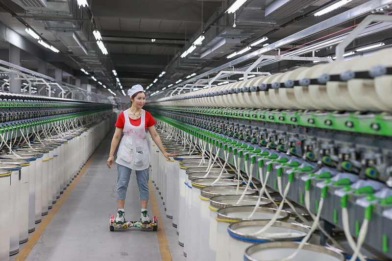 A staff member works while on a hoverboard at a factory in Ili Kazak Autonomous Prefecture, northwest China's Xinjiang Uygur Autonomous Region, September 19, 2023. /CFP