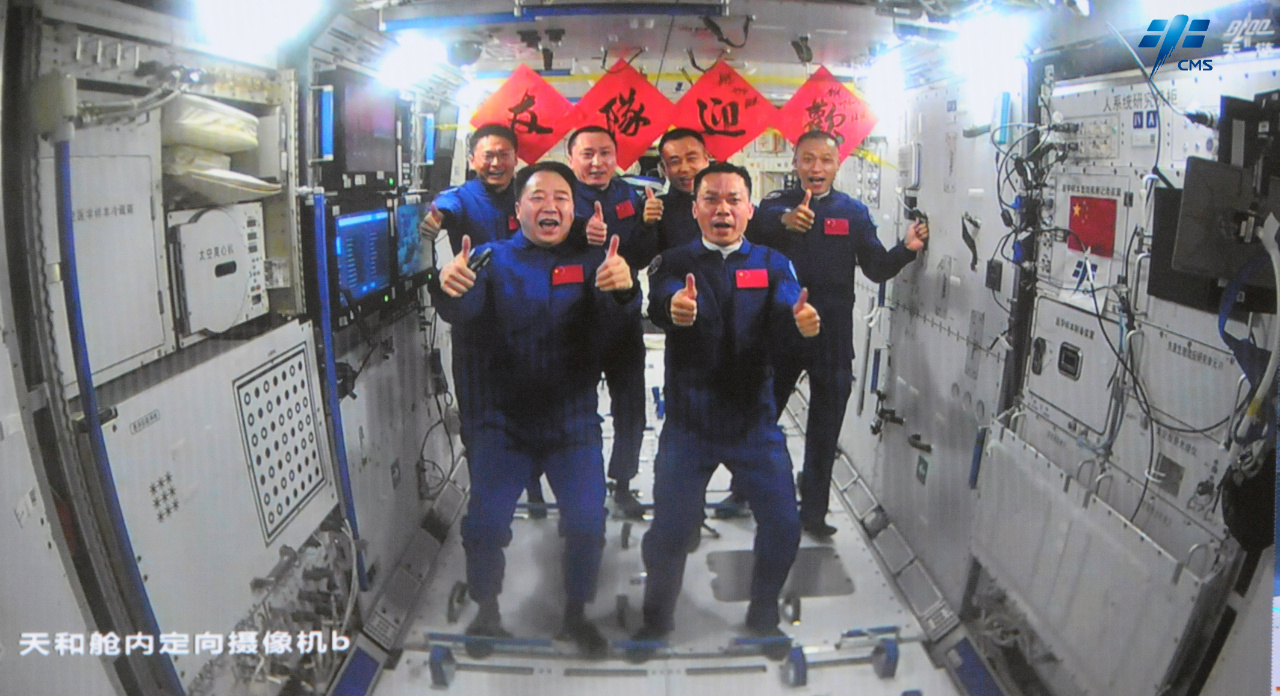 Two teams of six taikonauts show thumbs up in the core module of China Space Station for a group photo. /CMSA