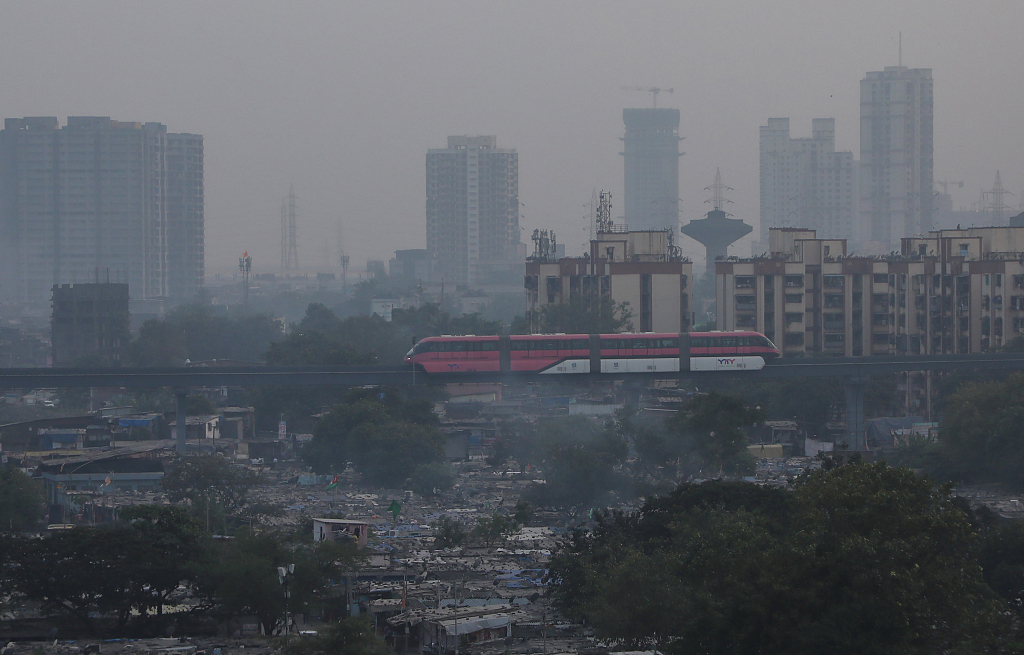 A Monorail passes through a slum area on a smoggy evening in Mumbai, India, 21 October, 2023. /CFP