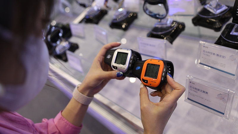 A visitor compares two watches supported by BDS at an expo in Zhengzhou, Henan Province, September 21, 2022. /CFP