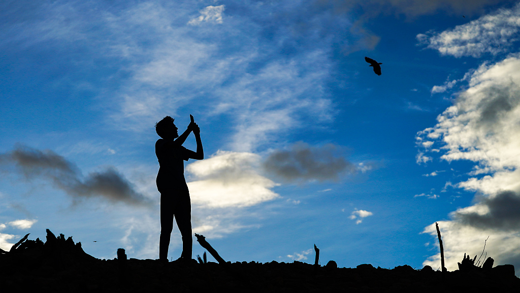 A visitor takes pictures of the ruins of the dried Moragahakanda reservoir on September 2, 2023, in Moragahakanda, Sri Lanka. /CFP