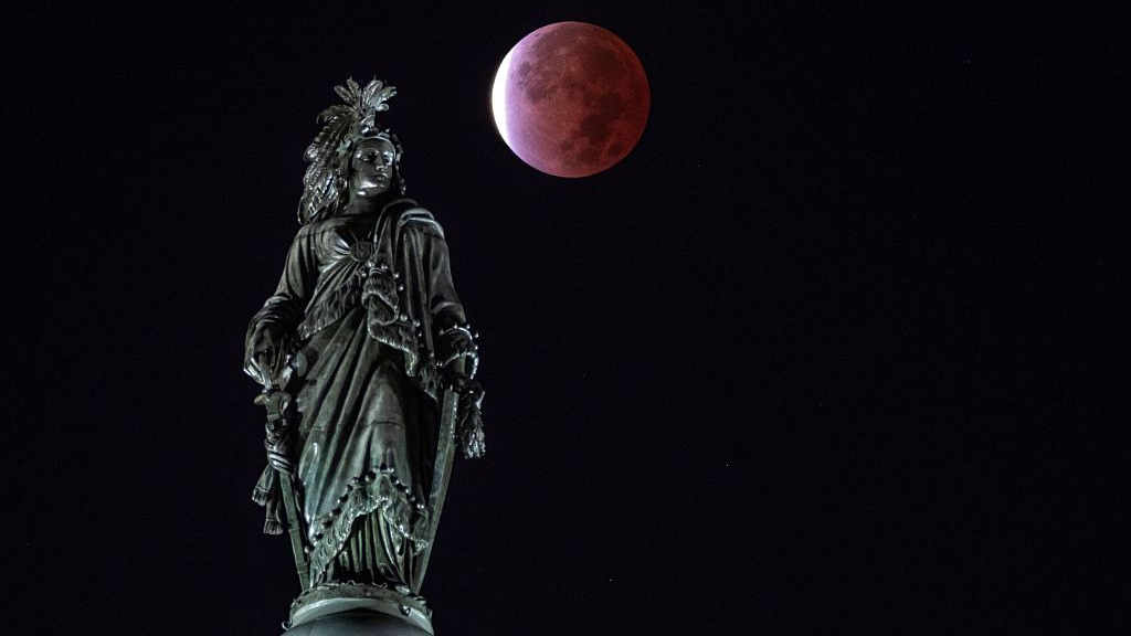 Se observa un eclipse lunar parcial detrás de la Estatua de la Libertad en Estados Unidos el 19 de noviembre de 2021. /CFP