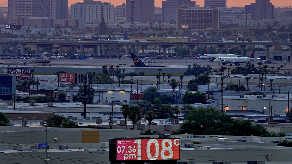 A sign displays an unofficial temperature as jets taxi at Sky Harbor International Airport at dusk, July 12, 2023, in Phoenix, U.S. /CFP