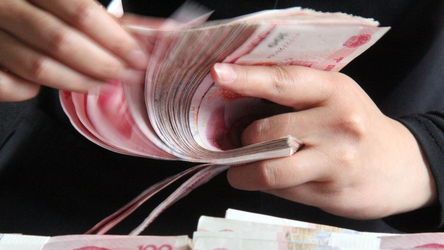 File photo shows a staff member of a Chinese bank counting cash. /Xinhua