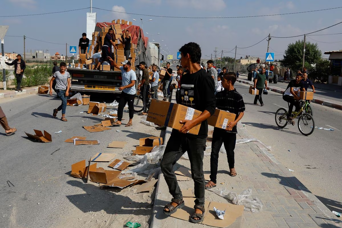 Palestinians carry aid that has fallen from a truck, amid shortages of food supplies during the ongoing conflict between Israel and Palestinian Islamist group Hamas, in Rafah in the southern Gaza Strip, November 2, 2023. /Reuters