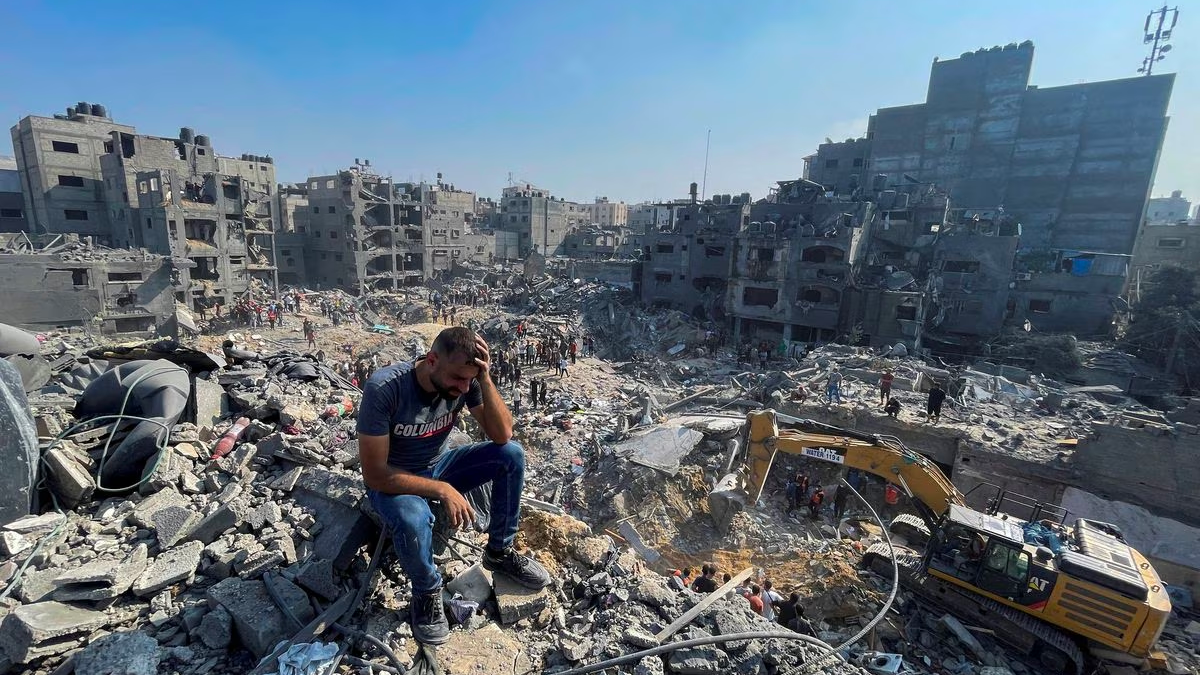 A man sits atop the rubble as Palestinians comb through the debris for survivors in the Jabalia refugee camp, following an Israeli airstrike on residential areas in the northern Gaza Strip, November 1, 2023. /Reuters