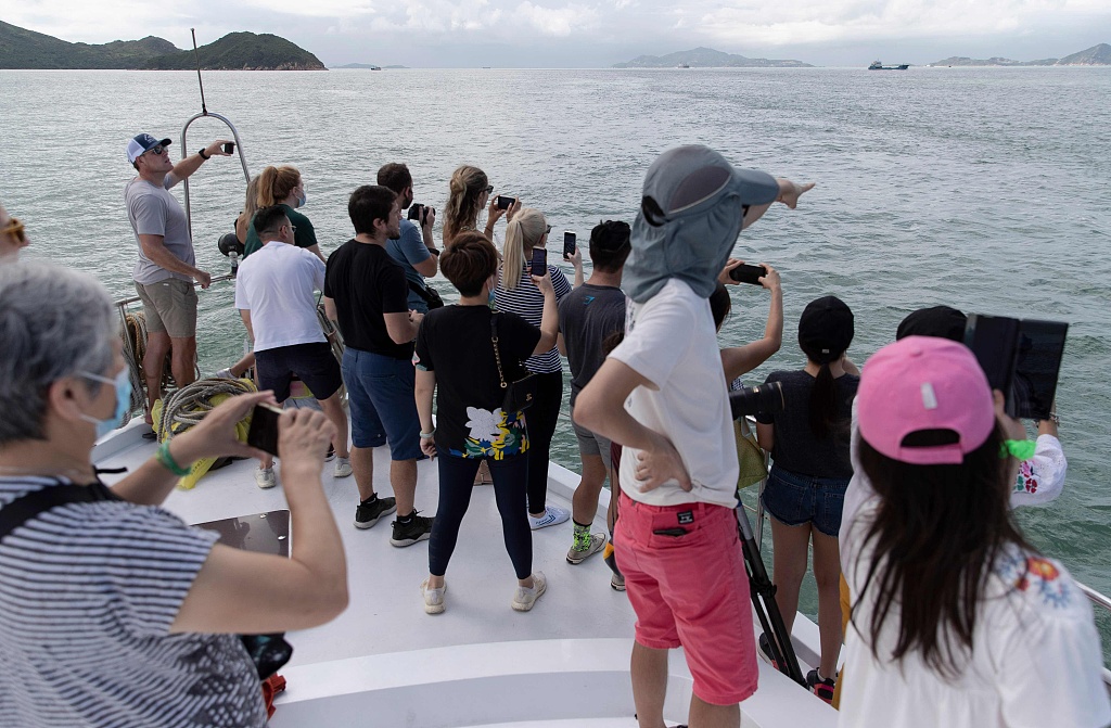 This photograph taken on September 20, 2020 shows people looking for Chinese white dolphins, also known locally as 