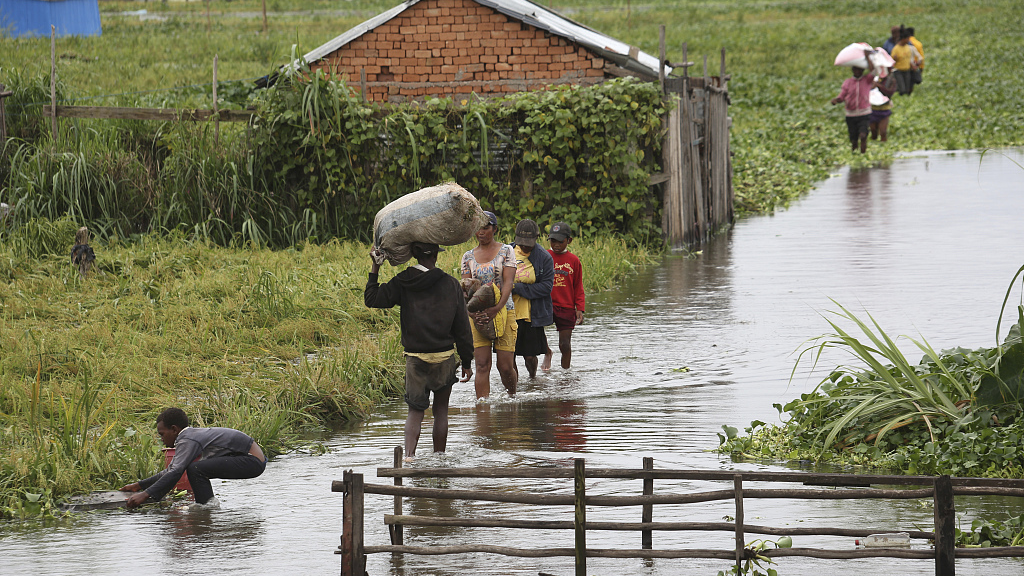 Residents wade through floodwater around their homes after heavy rain in Antananarivo, Madagascar on January 19, 2022. /CFP