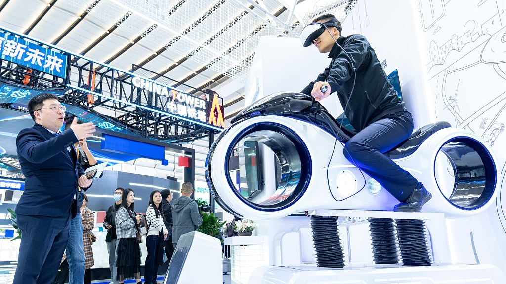 A visitor experiences a virtual reality motorcycle simulator based on 5G networks at the Light of the Internet Expo, a part of the 2023 WIC Wuzhen Summit, November 7, 2023. /CFP