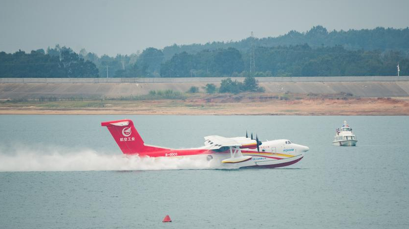 An AG600M firefighting aircraft gathers water during a gathering and dropping water test in Jingmen, central China's Hubei Province, September 27, 2022. /Xinhua
