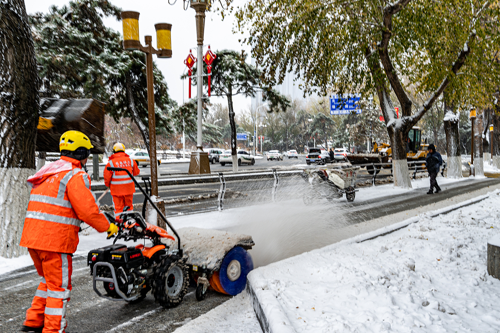 Sanitation workers clear snow in Changchun City of northeast China's Jilin Province on November 6, 2023. /CFP