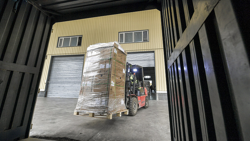 Workers use forklifts to transfer goods at the cross-border e-commerce sorting and customs clearance center in the Alashankou Comprehensive Bonded Zone in Xinjiang, China, November 4, 2023. /CFP