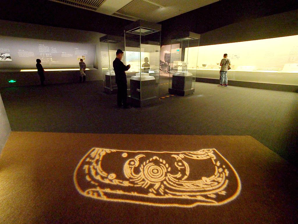 A photo taken on November 8, 2023, shows visitors browsing a special exhibition at the National Museum of China in Beijing to mark the 50th anniversary of the discovery of Neolithic Age Hemudu Culture relics. /CFP