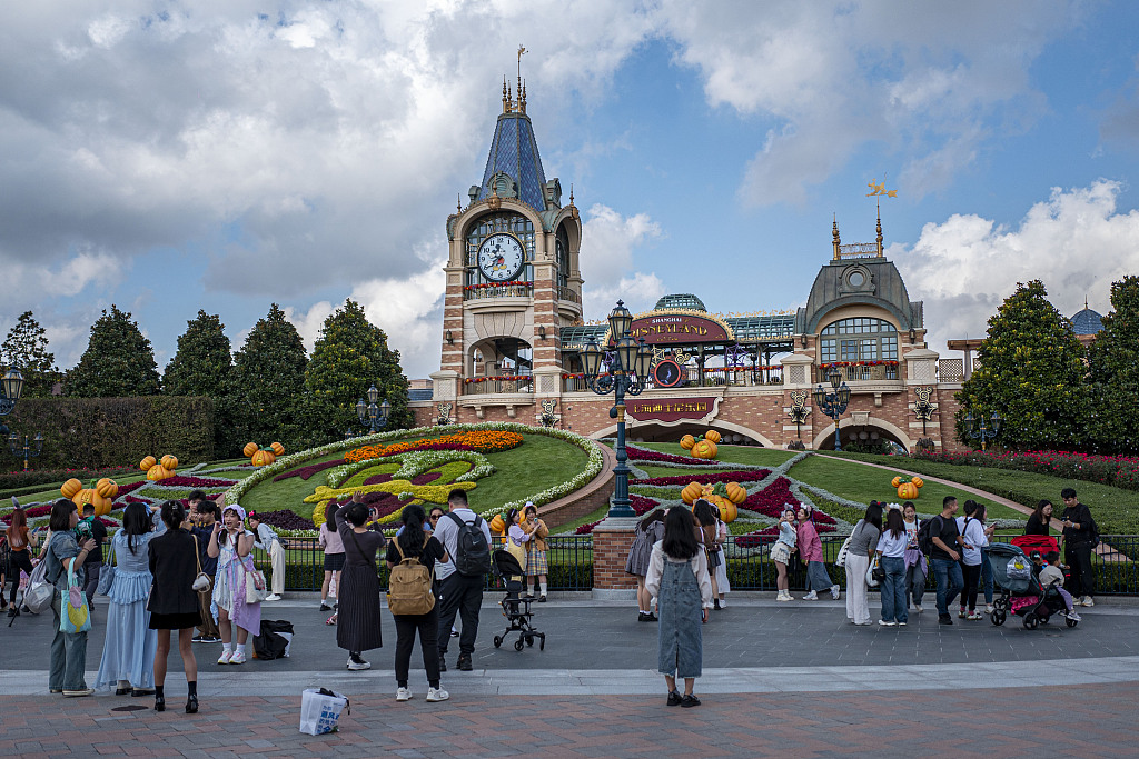 A photo shows people taking pictures at the entrance of Shanghai Disney Resort on October 30, 2023. /CFP