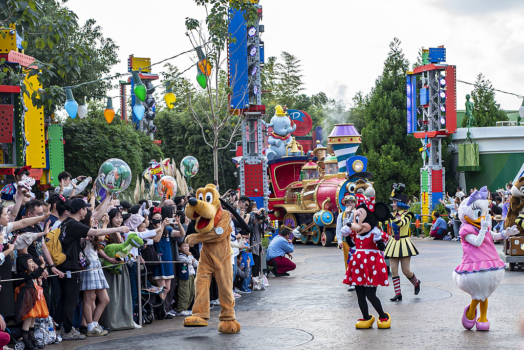 A photo shows visitors interacting with performers during a parade at Shanghai Disney Resort on October 30, 2023. /CFP