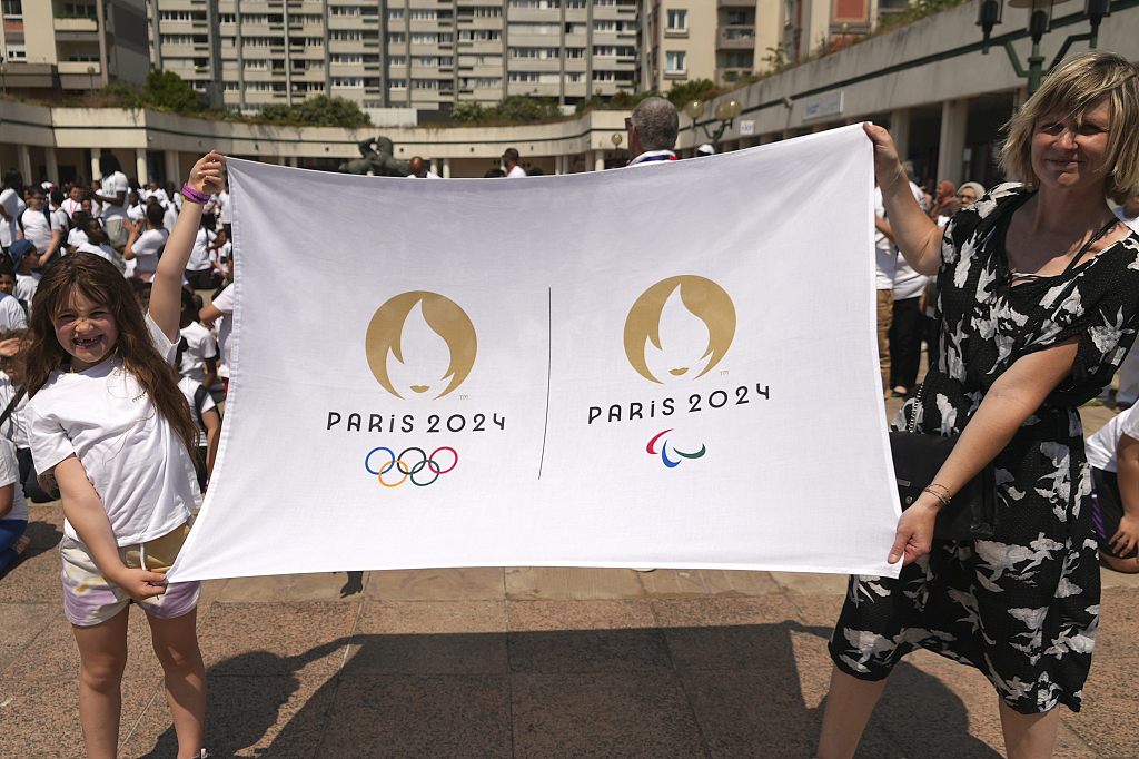 People display the logos of the Paris 2024 Olympic and Paralympic Games during a flashmob to promote sports and the 2024 Paris summer Olympics, in Epinay-sur-Seine, north of Paris, France, June 7, 2023. /CFP 
