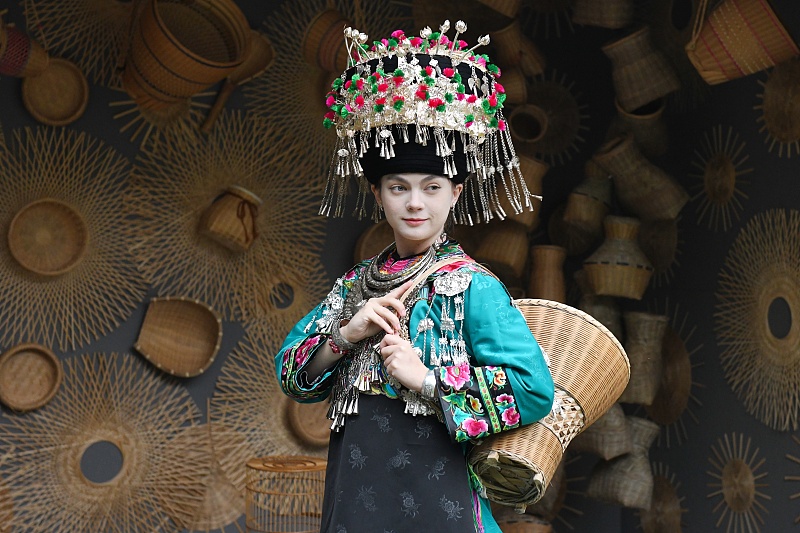 A Russian woman dressed in traditional Miao costume poses for photos in Fenghuang County, Hunan Province, November 10, 2023. /CFP