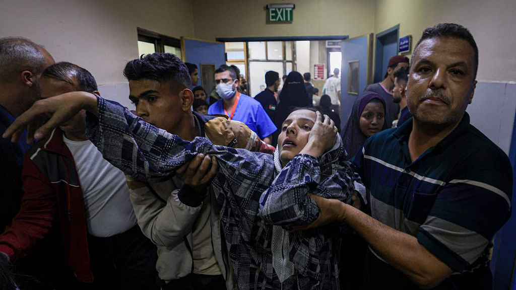 A wounded Palestinian woman from the Baraka family is helped by men to reach the emergency ward at Nasser Hostpial in Khan Yunis in the southern Gaza Strip, following Israeli air strikes that hit their building on November 13, 2023. /CFP