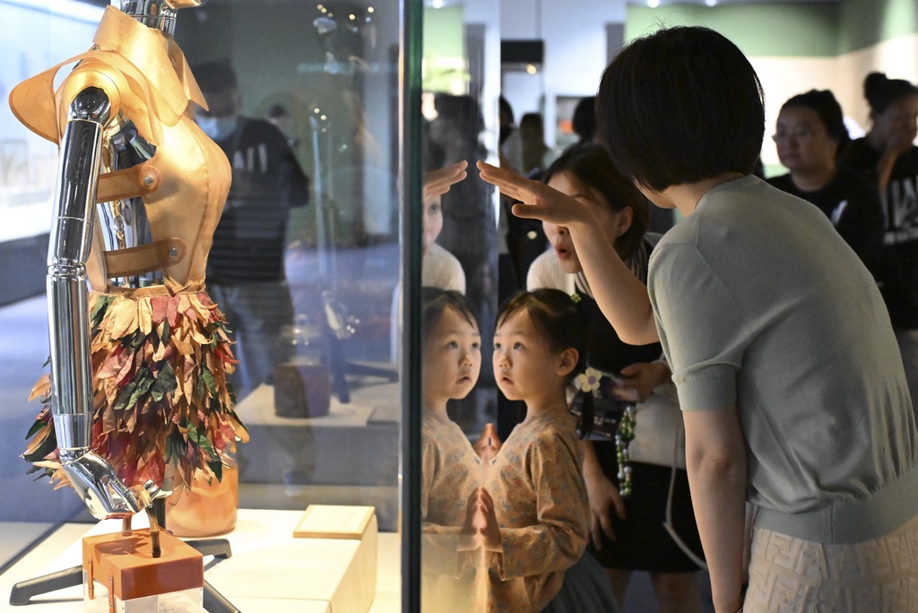 A photo shows visitors viewing a display at the science art exhibition at the National Natural History Museum of China in Beijing. /IC