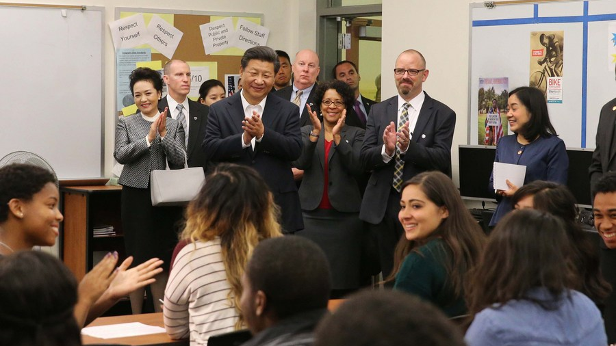 Xi Jinping (back, 4th L) and his wife Peng Liyuan (back, 1st L) greet teachers and students during their visit to Lincoln High School in Tacoma of Washington State, U.S., September 23, 2015. /Xinhua