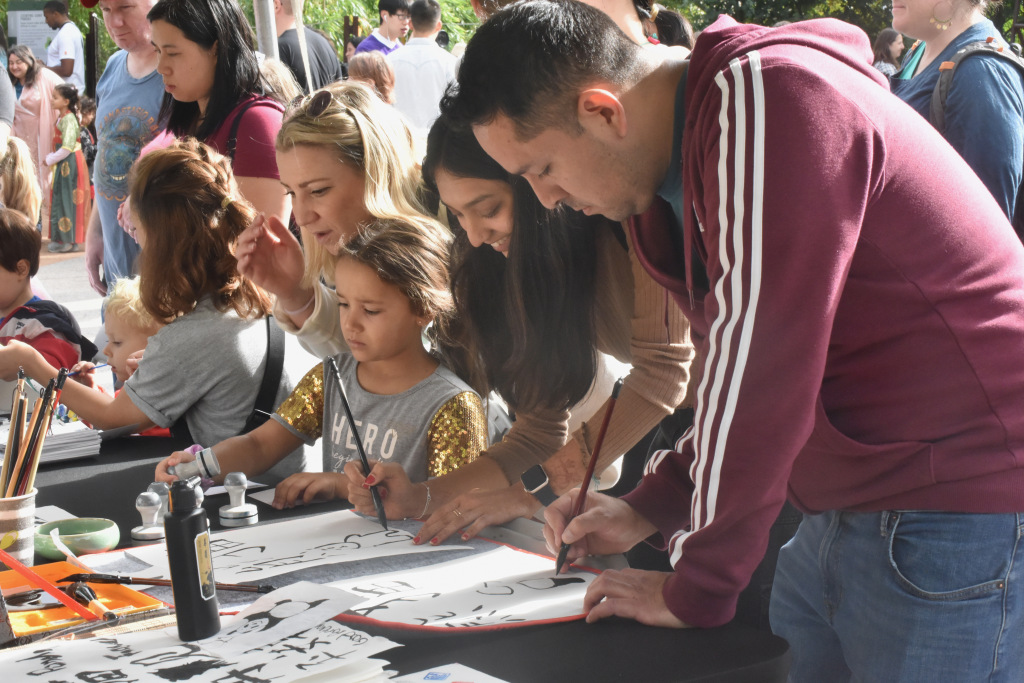 Visitors paint and write with Chinese calligraphy brushes at the 