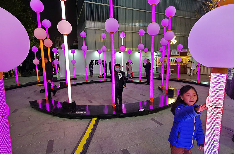 Visitors interact with artistic light installations in the Chaoyang district of Beijing during a light show, November 18, 2023. /CFP