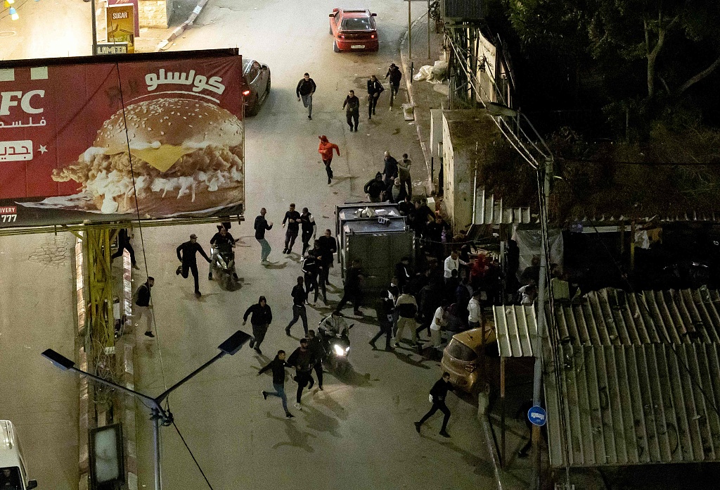 Palestinian youths run during a raid by the Israeli army in the occupied West Bank Jenin refugee camp overnight on November 16, 2023. /CFP