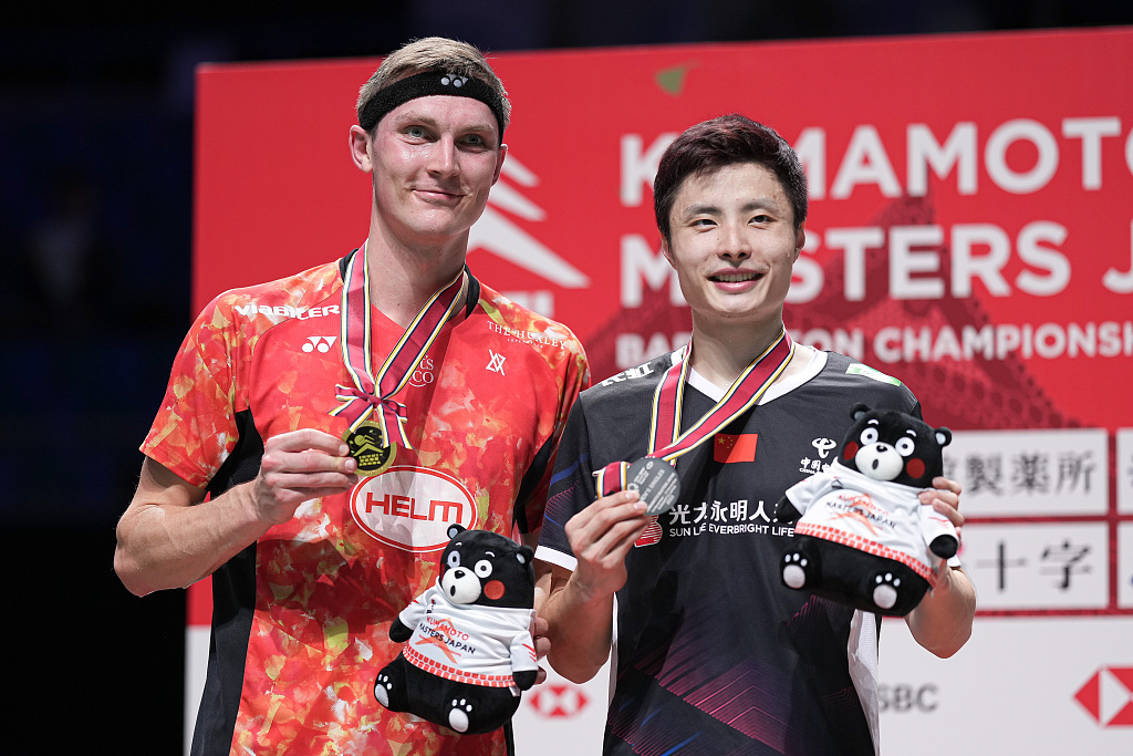 Viktor Axelsen (L) of Denmark and Shi Yuqi of China celebrate on the podium after their men's singles final during the BWF Japan Masters in Kumamoto, Japan, November 19, 2023. /CFP