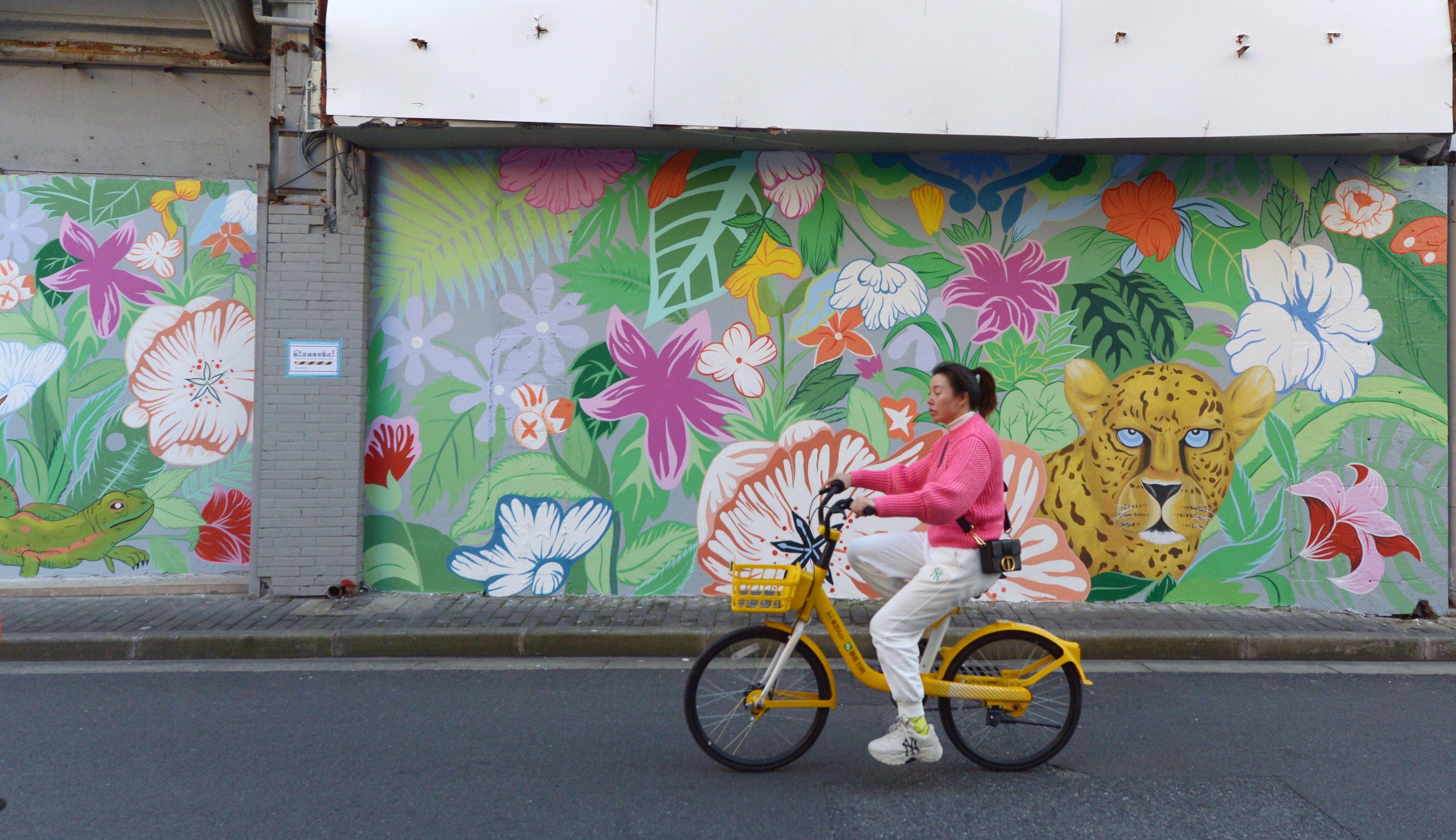 A woman passes by the freshly decorated murals on Fangbang Middle Road in Shanghai on November 18, 2023. /IC