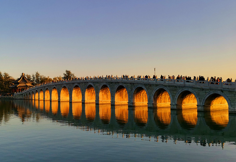The twilight illuminates the arches of the Seventeen Arch Bridge at the Summer Palace in Beijing on November 19, 2023. /CFP