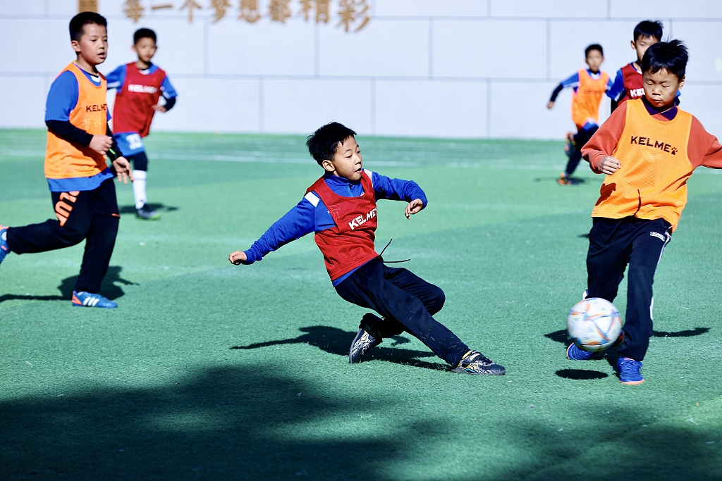 Elementary students take part in a football training session at a school in Zhengzhou, Henan Province, November 19, 2023. /CFP