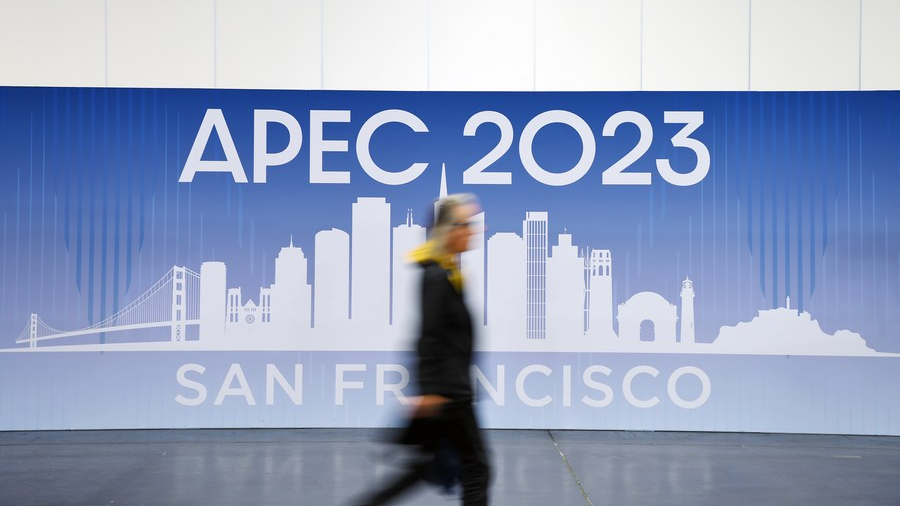 A journalist walks past a poster at the APEC 2023 International Media Center in San Francisco, the United States, November 14, 2023. /Xinhua