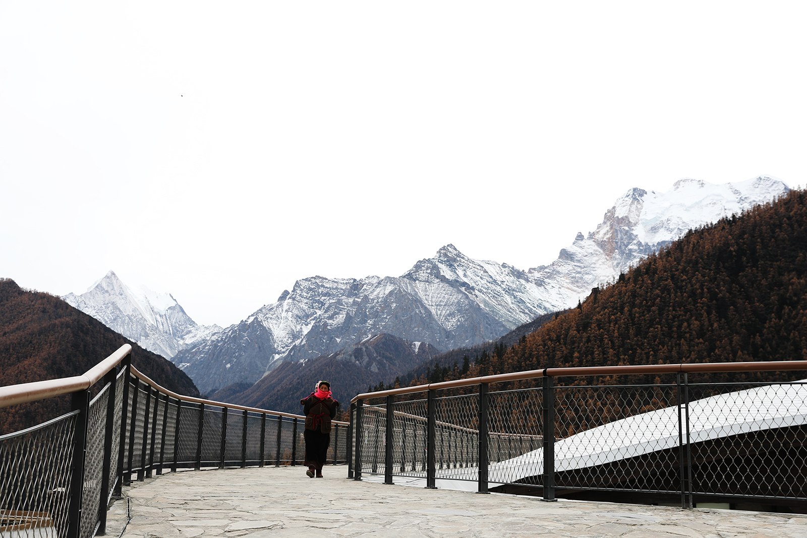 A Tibetan woman carries her child on a walk through Yading Village set against the backdrop of snow-capped mountains at Daocheng Yading Nature Reserve in Ganzi, Sichuan. /CGTN