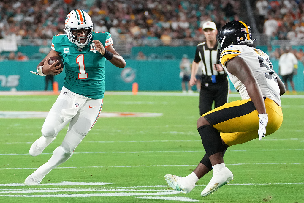 Tua Tagovailoa (L) of the Miami Dolphins runs the ball against Devin Bush of the Pittsburgh Steelers during their NFL game at the Hard Rock Stadium in Miami Gardens, U.S., October 23, 2022. /CFP 