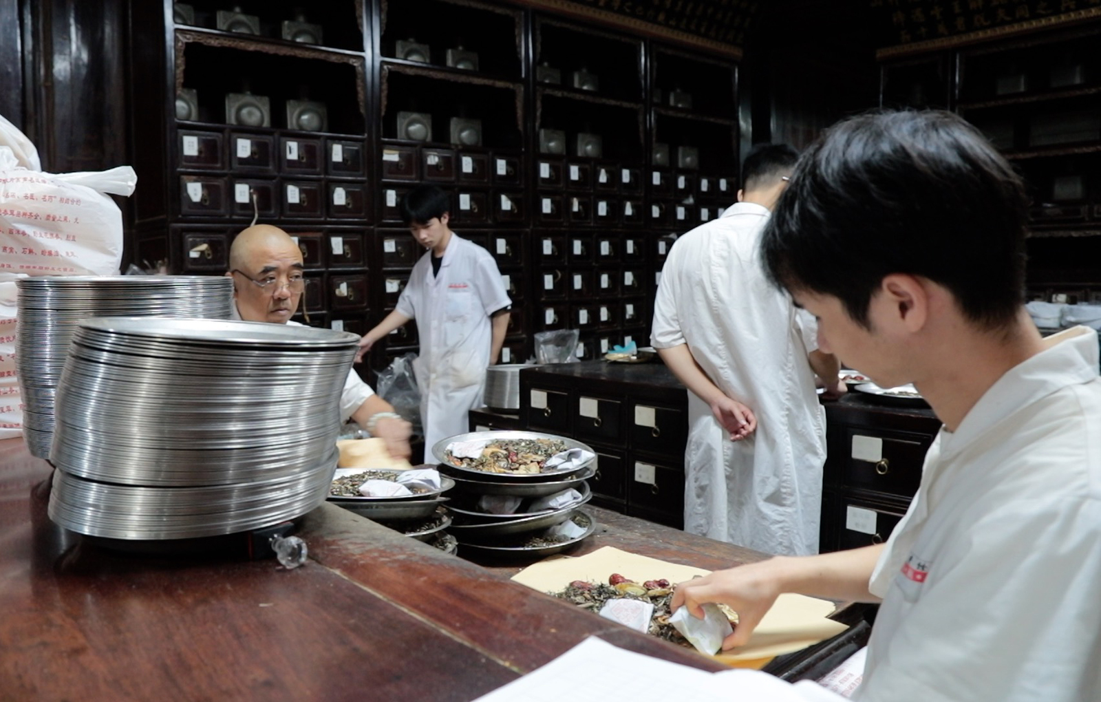 Pharmacists package up plates of traditional Chinese medicine at the Hu Qingyutang Chinese Medicine Museum on Qinghefang Street in Hangzhou, Zhejiang Province. /CGTN