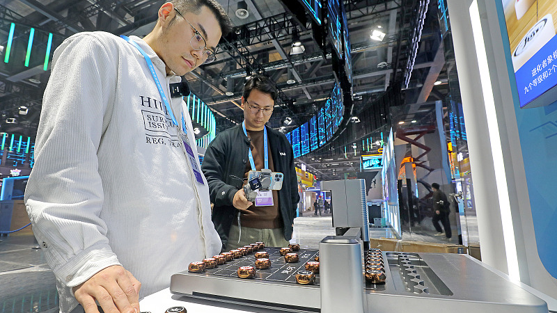 A visitor plays Chinese chess with a robot before the opening of the 2nd Global Digital Trade Expo in Hangzhou, November 21, 2023. /CFP