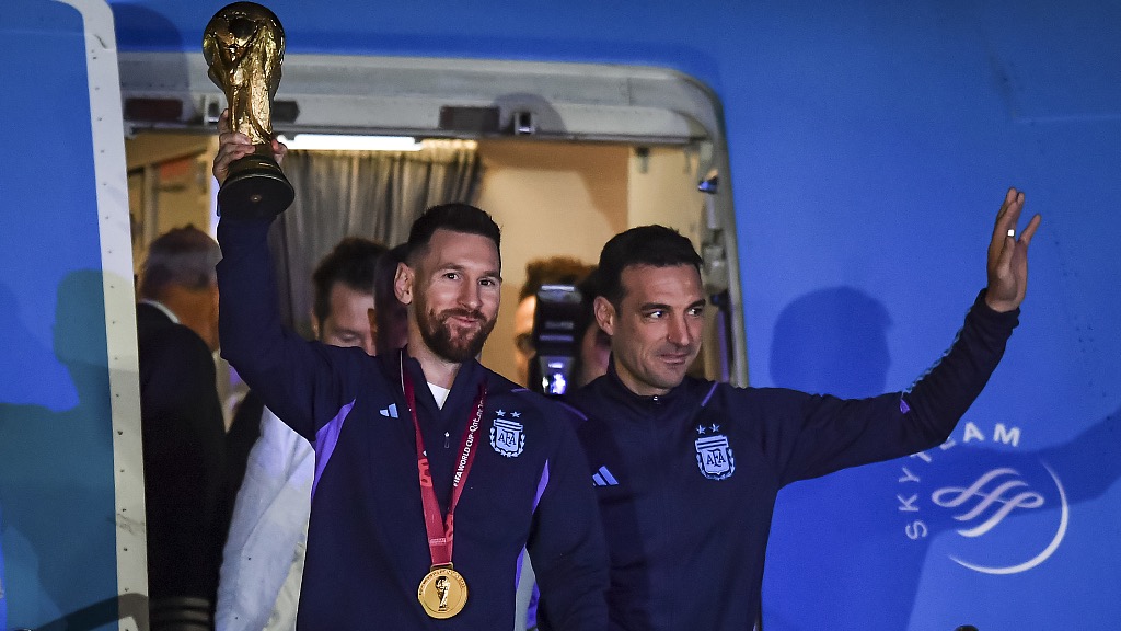 Lionel Scaloni (R) and Argentina captain Lionel Messi of Argentina display the World Cup trophy during the arrival of the Argentina team in Buenos Aires, Argentina, December 20, 2022. /CFP