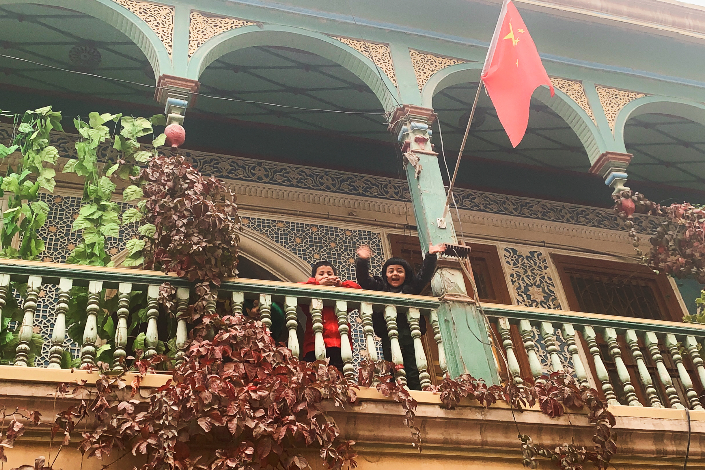 A photo shows two children on a balcony in Kashgar, Xinjiang. /CGTN