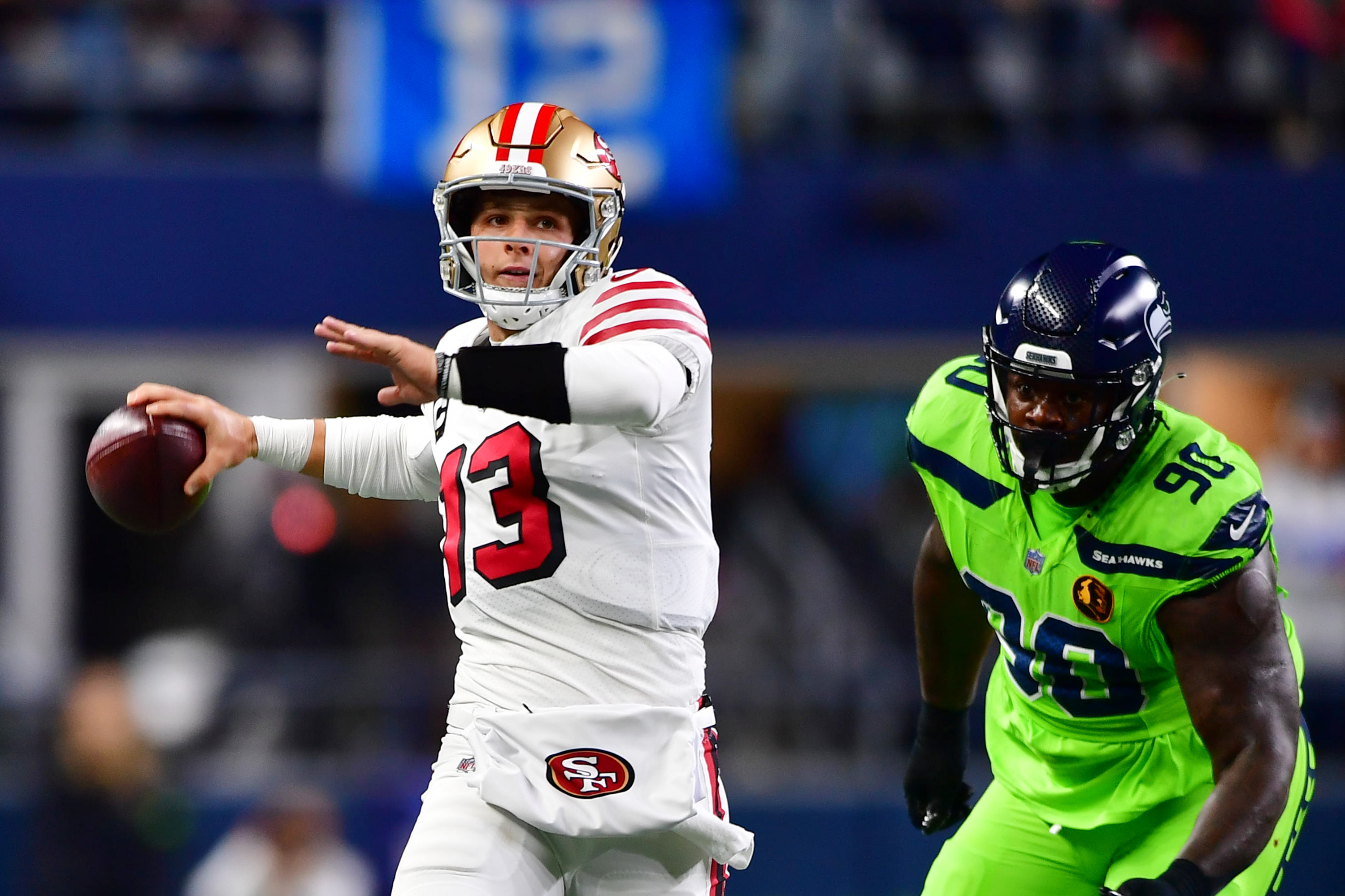 Quarterback Brock Purdy (L) of the San Francisco 49ers passes in the game against the Seattle Seahawks at Lumen Field in Seattle, Washington, November 23, 2023. /CFP