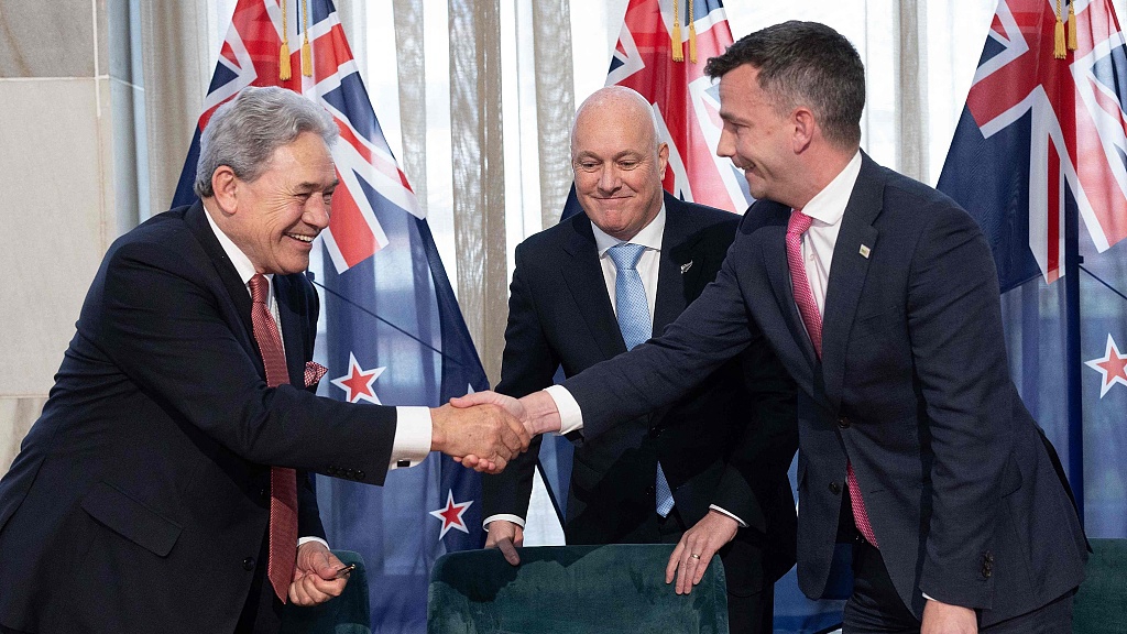 David Seymour, leader of the ACT New Zealand party (R), shakes hands with Winston Peters, leader of New Zealand First party (L), as New Zealand's incoming Prime Minister Christopher Luxon looks on after signing an agreement to form a three-party coalition government at Parliament in Wellington, New Zealand, November 24, 2023. /CFP