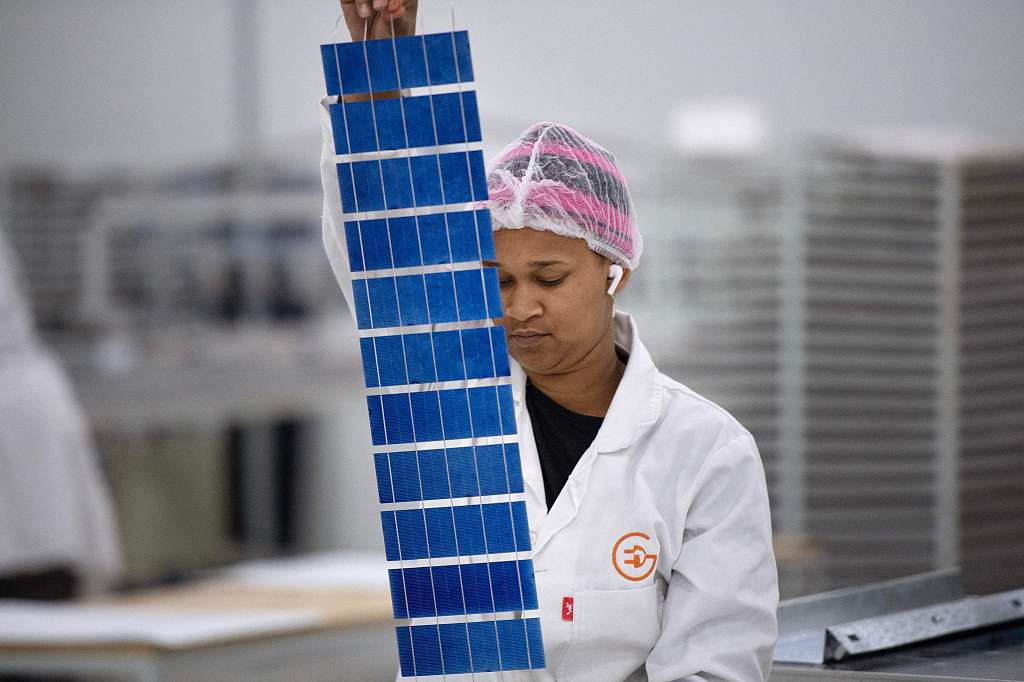A woman working at EnerG Africa, a factory making solar panels with only female employees, inspects a component in Cape Town on October 25, 2023. /CFP