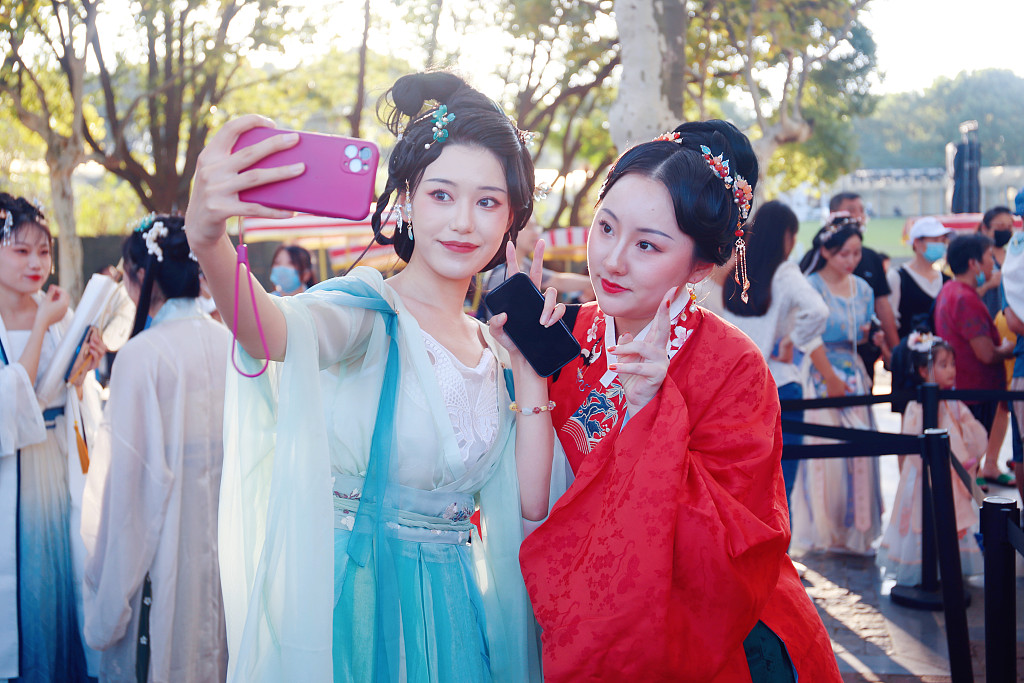 Two women wearing traditional Chinese costumes attend a music festival in Shanghai, on October 3, 2021. /CFP