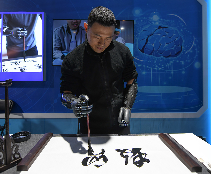 The bionic technology enables a man with disabilities to perform calligraphy at the second Global Digital Trade Expo in Hangzhou, November 23, 2023. /CFP