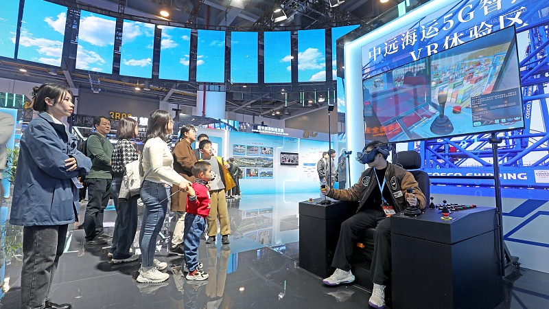 A visitor wearing a virtual-reality headset tries to operate containers to experience intelligent technology for ports at the second Global Digital Trade Expo in Hangzhou, November 26, 2023. /CFP