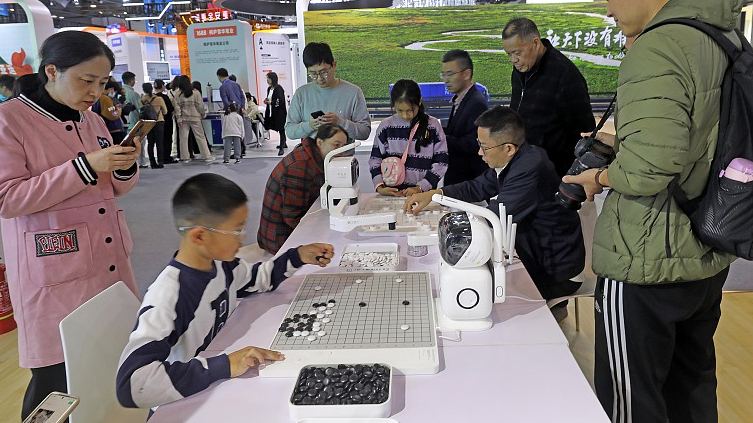 Visitors play the board game Go with a robot at the second Global Digital Trade Expo in Hangzhou, November 26, 2023. /CFP