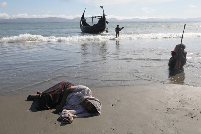 A refugee collapse from exhaustion as they arrive by a wooden boat from Myanmar to the shore of Shah Porir Dwip, in Teknaf, near Cox's Bazar in Bangladesh, October 1, 2017. /Reuters

