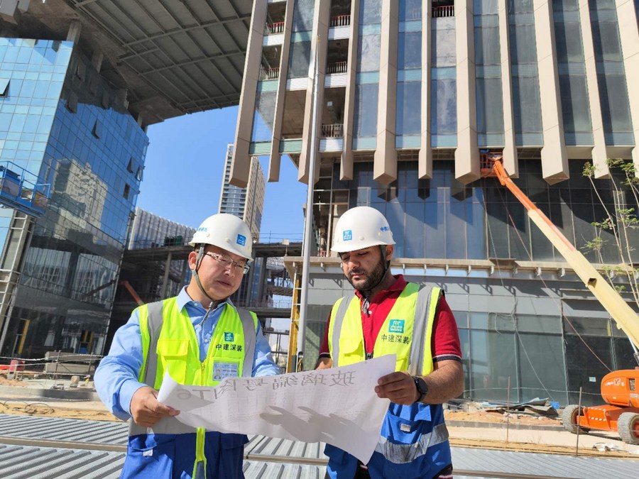 Cheng Wei (L), the manager of Egypt's CBD project of China Construction Shenzhen Decoration Company, consults with an Egyptian colleague at the worksite in the CBD of Egypt's new administrative capital, September 24, 2023. /Xinhua