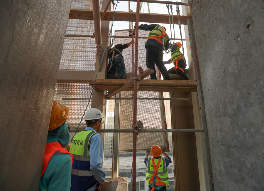 Workers installing the glass curtain walls of a building in the CBD of Egypt's new administrative capital, November 24, 2023. /Xinhua