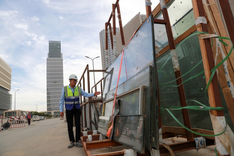 Xu Xiaoxiao, a project manager of China Construction Shenzhen Decoration Company, inspects the glass frames used for installing the glass curtain walls of the buildings in the CBD of Egypt's new administrative capital, November 24, 2023. /Xinhua