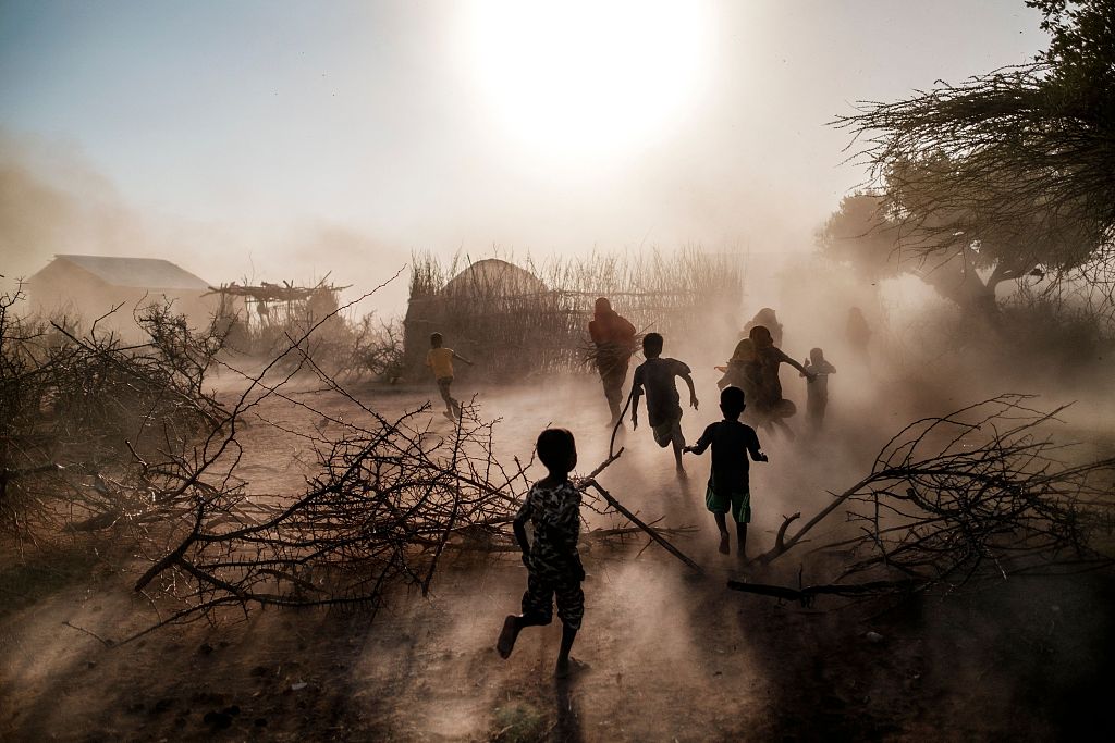 Children and women run among a cloud of dust at the village of El Gel, 8 kilometers from the town of K'elafo, Ethiopia, January 12, 2023. /CFP